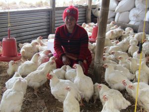 ETC women's group member at her poultry farm, 2019