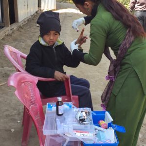 Teacher uses ETC-provided first aid supplies to help boy with injured finger